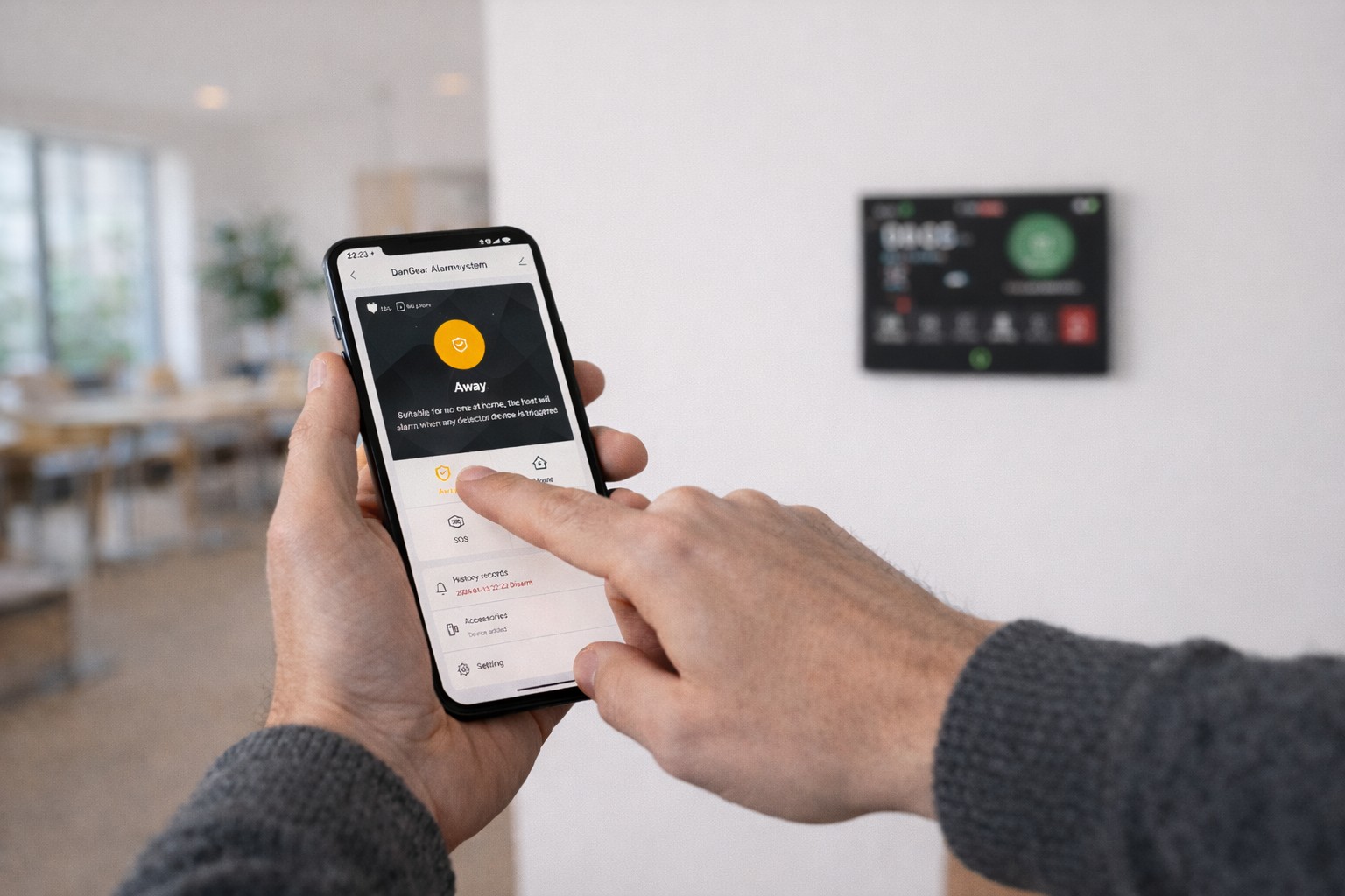 Hånd som betjener SmartLife app og DanGear alarmsystem